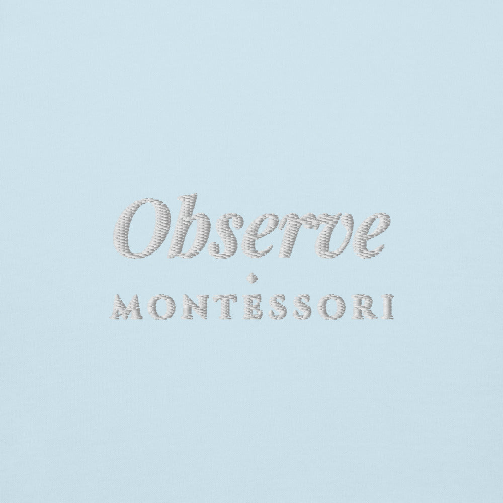 Observe Embroidered Hoodie in Sky Blue, close-up of the front embroidery.